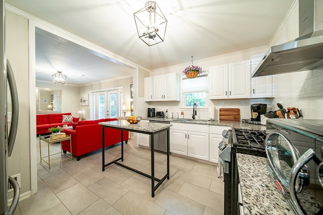 3422 Malatche Dr, Columbus, GA 31907 - kitchen featuring wall chimney range hood, stainless steel appliances, a chandelier, crown molding, and white cabinetry