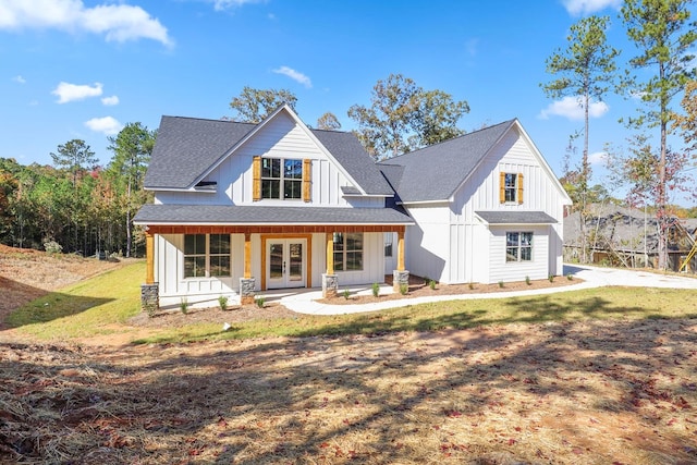 view of front of property with french doors, covered porch, and a front yard