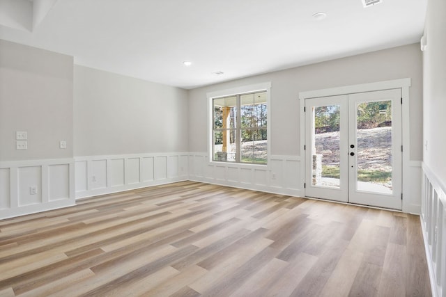 unfurnished room with french doors and light wood-type flooring