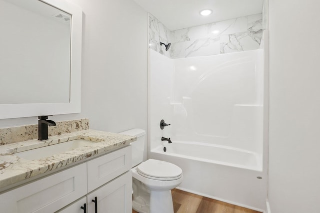 full bathroom with toilet, vanity, tiled shower / bath combo, and hardwood / wood-style flooring