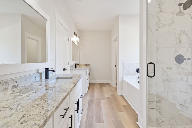 bathroom featuring hardwood / wood-style floors, vanity, and plus walk in shower