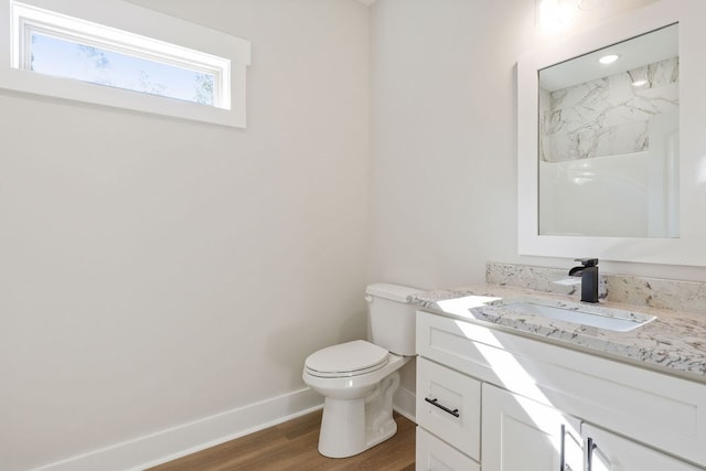 bathroom with hardwood / wood-style floors, vanity, and toilet