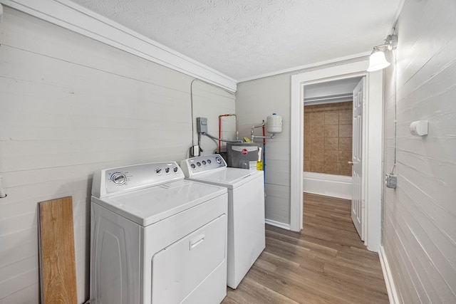 7 Magnolia St, Columbus, GA 31904 - washroom with washer and clothes dryer, light wood-type flooring, a textured ceiling, and gas water heater