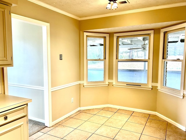 unfurnished dining area featuring crown molding, a textured ceiling, baseboards, and light tile patterned floors