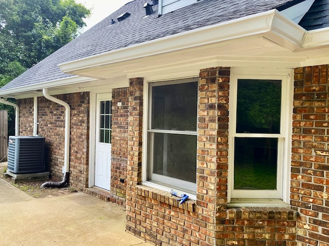7396 Cedar Creek Loop, Columbus, GA 31904 - doorway to property with a shingled roof, brick siding, and central air condition unit