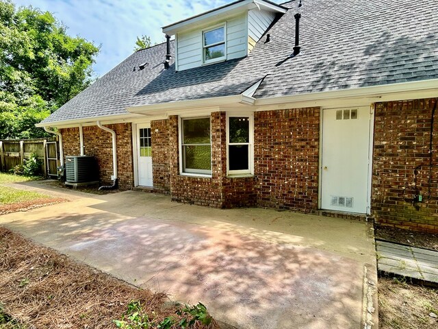 7396 Cedar Creek Loop, Columbus, GA 31904 - view of front facade featuring roof with shingles, central AC unit, fence, brick siding, and a patio