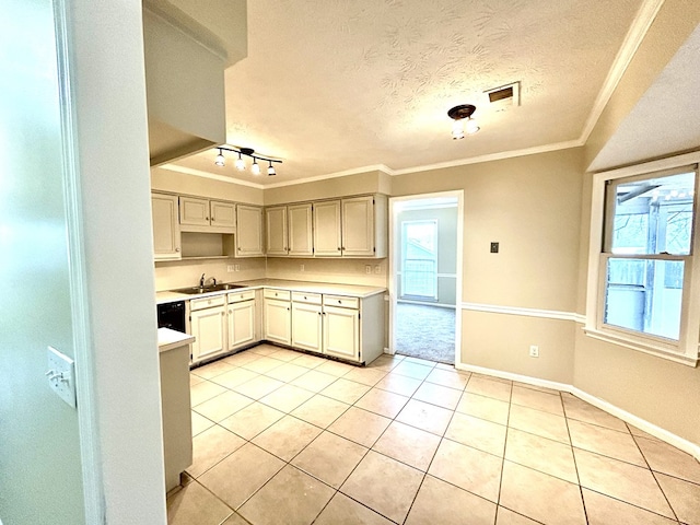 kitchen featuring a textured ceiling, light tile patterned floors, a sink, light countertops, and ornamental molding