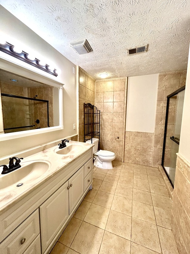 7396 Cedar Creek Loop, Columbus, GA 31904 - bathroom featuring a shower stall, tile patterned flooring, tile walls, double vanity, and toilet