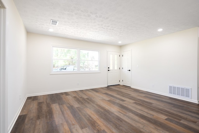foyer entrance featuring a textured ceiling, dark wood-style flooring, baseboards, and recessed lighting