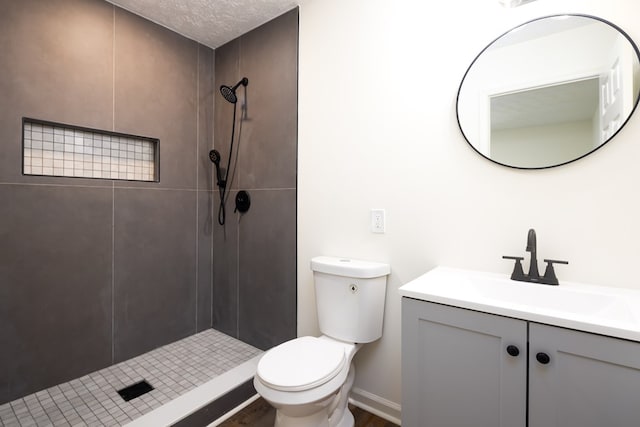 full bath with toilet, tiled shower, vanity, and wood finished floors