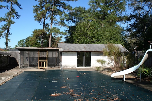 back of property featuring a patio area and a covered pool