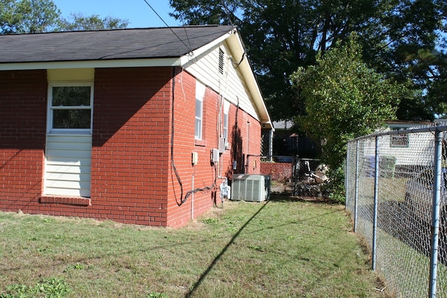 view of side of property with cooling unit and a yard