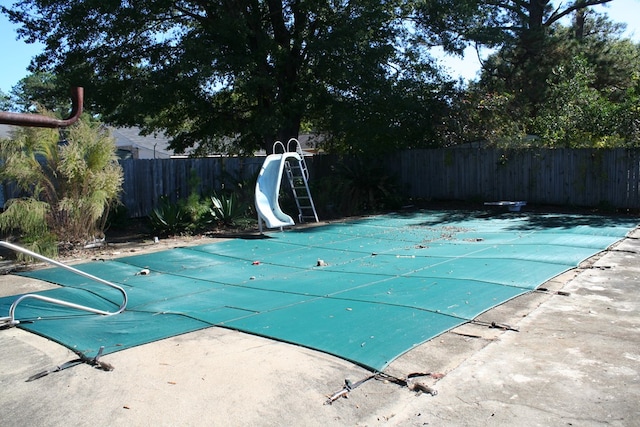 view of swimming pool featuring a patio and a water slide