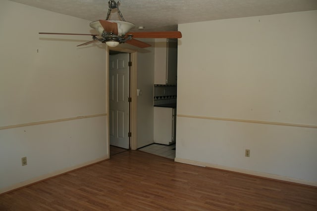 spare room with a textured ceiling, light hardwood / wood-style flooring, and ceiling fan