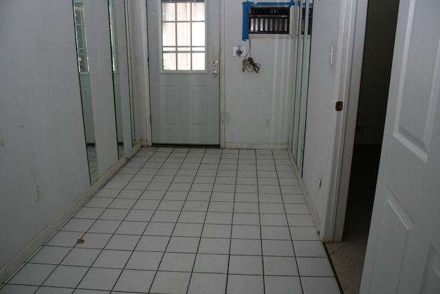 entryway featuring a wall unit AC and light tile patterned floors