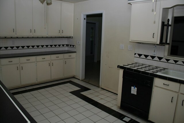 kitchen featuring decorative backsplash, white cabinetry, black dishwasher, and light tile patterned floors