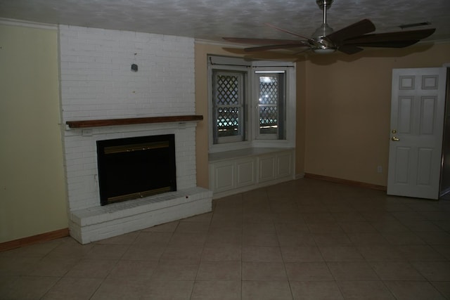 unfurnished living room featuring a brick fireplace, ornamental molding, a textured ceiling, ceiling fan, and light tile patterned floors