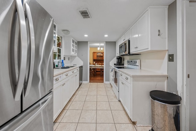 438 Newport Pl, Columbus, GA 31904 - kitchen featuring appliances with stainless steel finishes, a sink, light countertops, white cabinetry, and light tile patterned flooring
