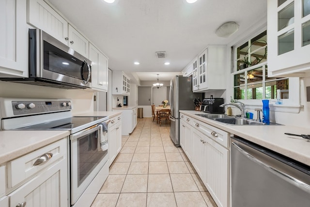 438 Newport Pl, Columbus, GA 31904 - kitchen with stainless steel appliances, a sink, white cabinetry, light tile patterned flooring, and recessed lighting