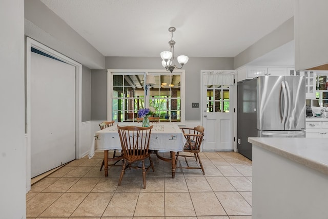 438 Newport Pl, Columbus, GA 31904 - dining area featuring a chandelier, light tile patterned flooring, and a wainscoted wall