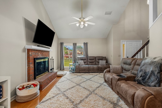 6538 Middleburg Dr, Columbus, GA 31909 - living area featuring high vaulted ceiling, wood finished floors, a ceiling fan, a brick fireplace, and stairway