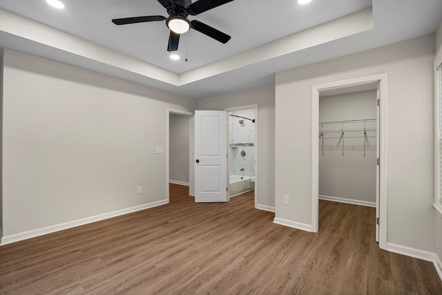 1712 39th St, Phenix City, AL 36867 - unfurnished bedroom featuring a spacious closet, wood finished floors, recessed lighting, ensuite bath, and a tray ceiling