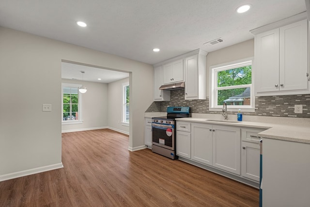1712 39th St, Phenix City, AL 36867 - kitchen with stainless steel electric range, under cabinet range hood, decorative backsplash, wood finished floors, and healthy amount of natural light