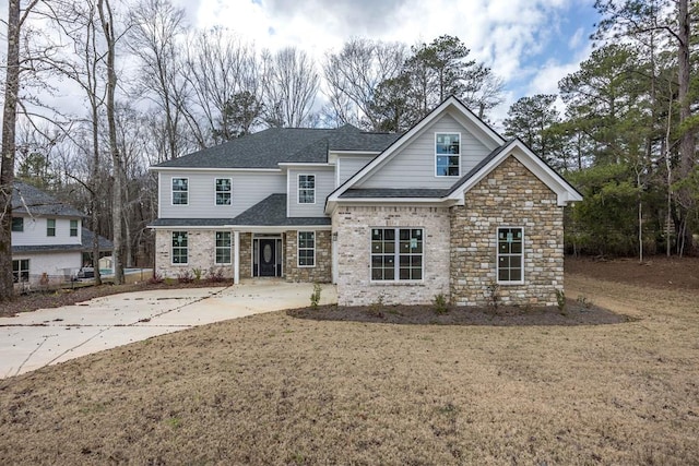 view of front of property featuring roof with shingles and a front lawn