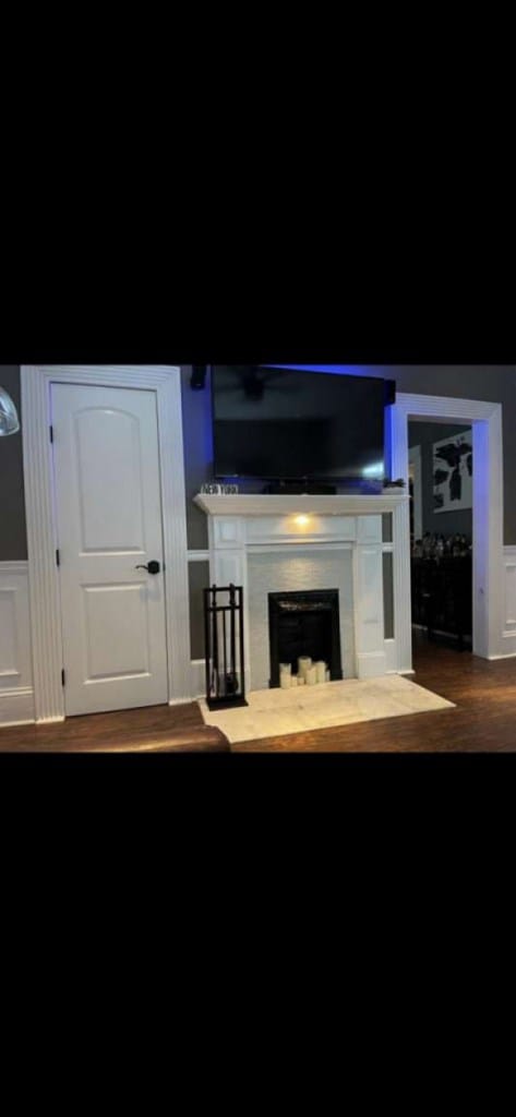 1314 Talbotton Rd, Columbus, GA 31901 - living area with a fireplace with raised hearth, wood finished floors, and a wainscoted wall