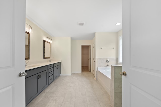 2276 Webbed Way, Opelika, AL 36804 - bathroom featuring double vanity, a garden tub, a spacious closet, and tile patterned floors