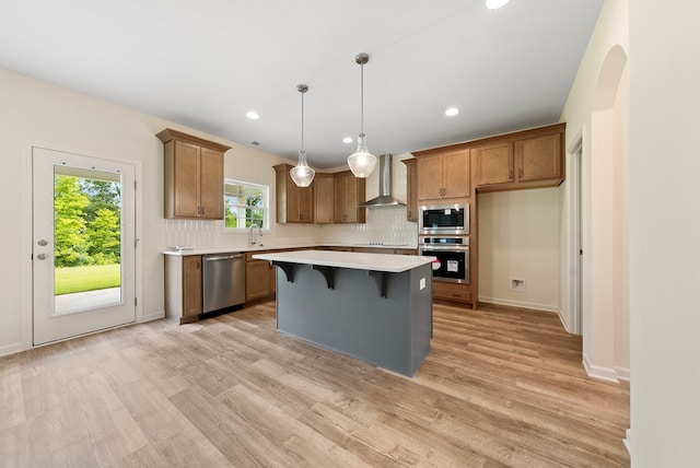 2276 Webbed Way, Opelika, AL 36804 - kitchen featuring appliances with stainless steel finishes, wall chimney exhaust hood, light countertops, tasteful backsplash, and brown cabinets