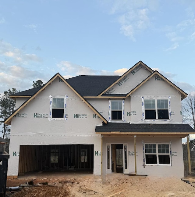 unfinished property featuring a garage and stucco siding