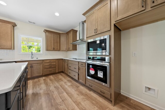 2276 Webbed Way, Opelika, AL 36804 - kitchen with stainless steel appliances, wall chimney exhaust hood, light wood-style floors, light countertops, and backsplash