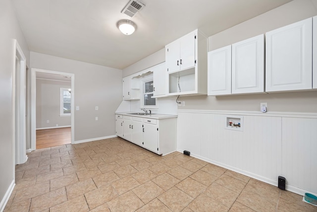 1402 41st St, Columbus, GA 31904 - washroom featuring cabinet space, washer hookup, wainscoting, light stone finish flooring, and baseboards