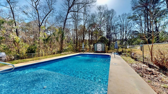 view of swimming pool with an outbuilding, a storage unit, a fenced backyard, and a fenced in pool