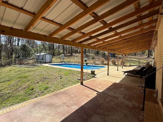 view of swimming pool with an outbuilding, a fenced in pool, a shed, a fenced backyard, and a patio area