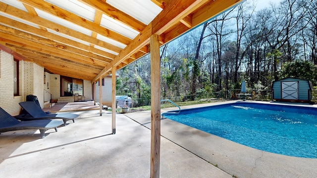 outdoor pool with a patio area, a storage shed, an outdoor structure, and fence