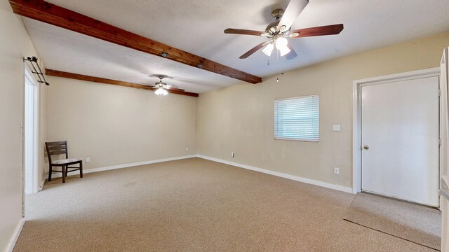 carpeted empty room with baseboards, beam ceiling, a textured ceiling, and ceiling fan