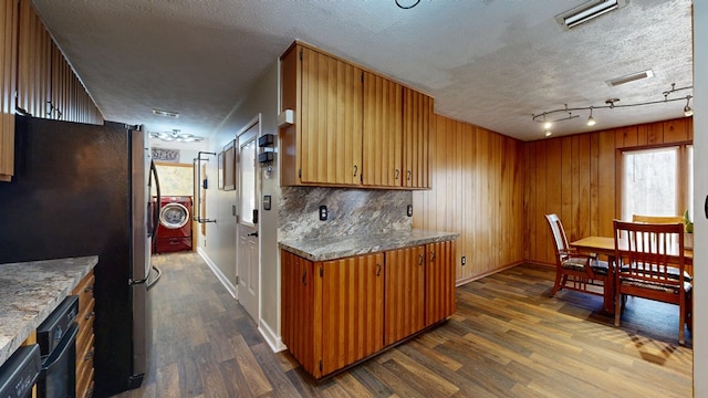 kitchen featuring visible vents, washer / dryer, dark wood-style floors, and freestanding refrigerator