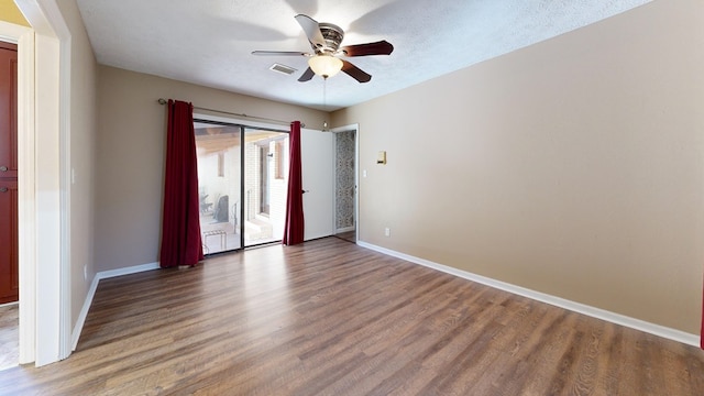 spare room with visible vents, baseboards, and wood finished floors