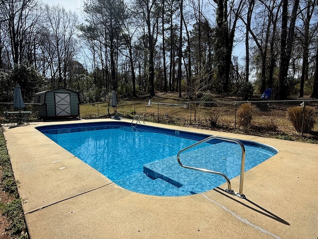 view of pool with fence, a fenced in pool, an outdoor structure, a storage unit, and a patio area