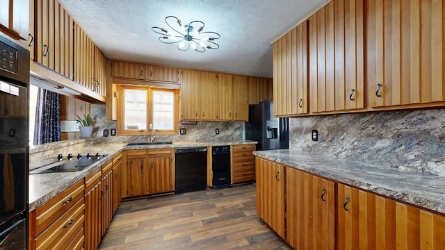 kitchen featuring dark wood-style floors, a sink, black appliances, a textured ceiling, and backsplash