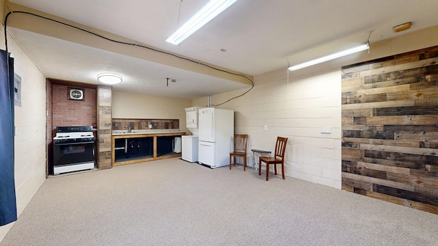 finished basement featuring visible vents, light colored carpet, freestanding refrigerator, and concrete block wall