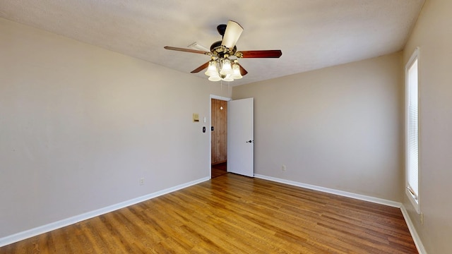 spare room featuring light wood-type flooring, baseboards, and a ceiling fan