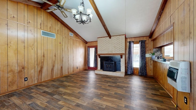 unfurnished living room with visible vents, wooden walls, beamed ceiling, dark wood-style floors, and heating unit