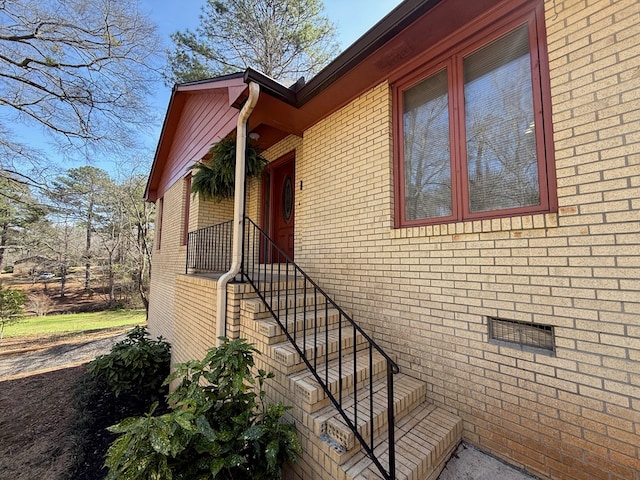 view of side of home with crawl space and brick siding