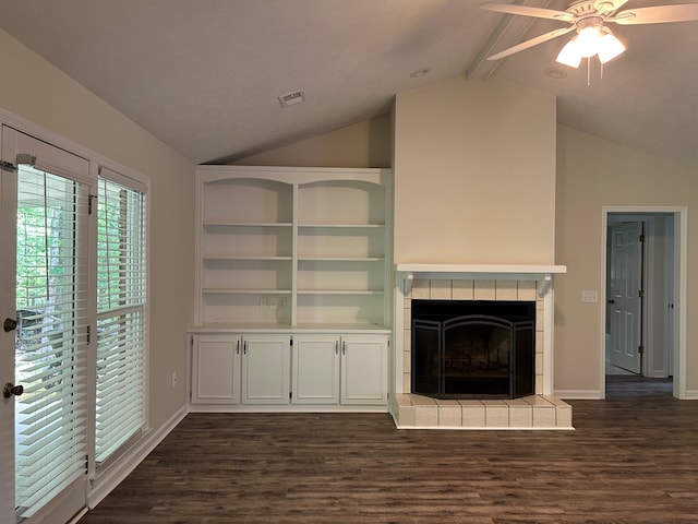 unfurnished living room featuring dark wood-style flooring, ceiling fan, a fireplace, baseboards, and vaulted ceiling with beams