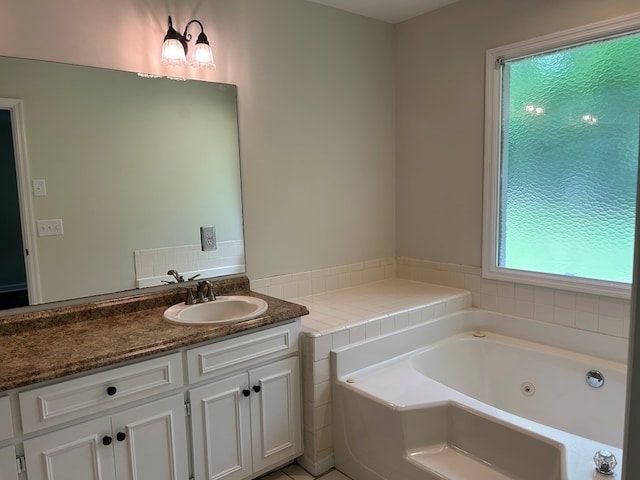 bathroom featuring a tub with jets and vanity