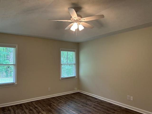 unfurnished room featuring dark wood-type flooring, baseboards, and a wealth of natural light