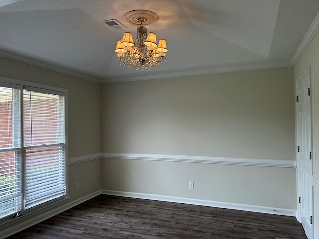 empty room featuring dark wood-style flooring, a chandelier, baseboards, a tray ceiling, and visible vents